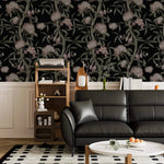 Blushing Blossoms wallpaper in living room with black leather sofa, wood shelving unit and white wainscoting