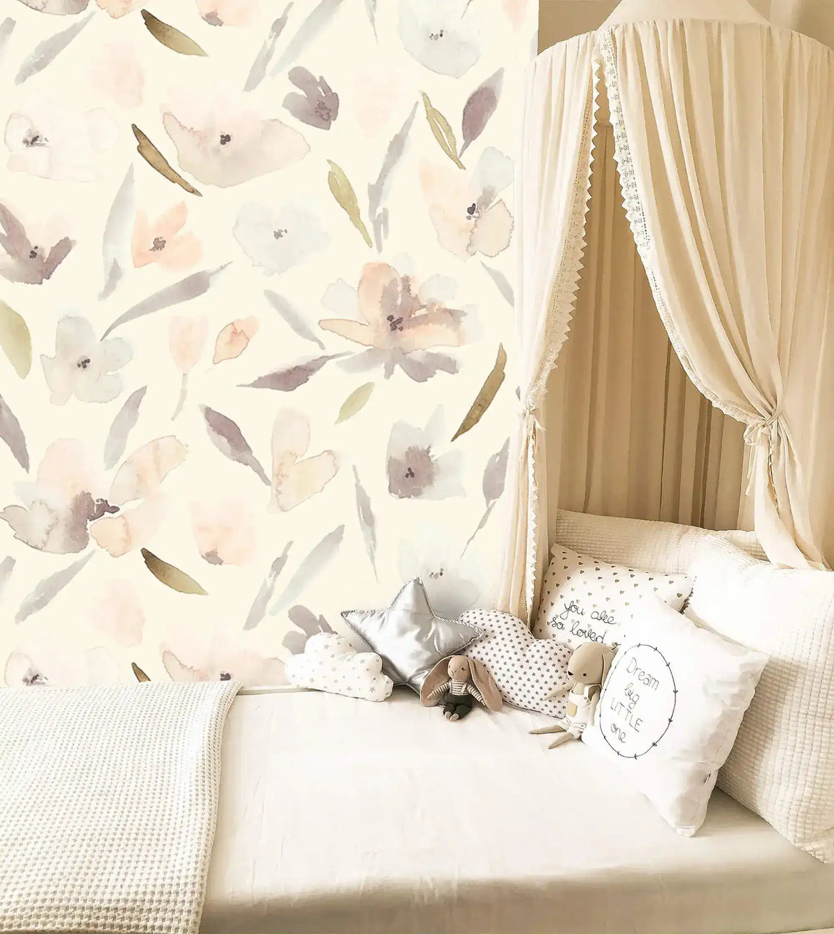 Nursery canopy nook with cushions against pastel watercolor blossom wallpaper, muted florals