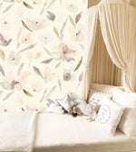 Nursery canopy nook with cushions against pastel watercolor blossom wallpaper, muted florals