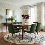 Dining room with wooden table and green chairs, floral arrangement, and decorative rug.