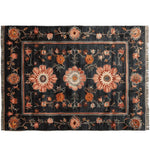A beautifully crafted area rug featuring a striking floral pattern in warm hues on a dark background. This wool rug, perfect for adding elegance to any living room, measures 8x10 feet, showcasing intricate hand-knotted details.