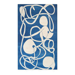 Ocean Flow rug shown face-down revealing plain white surface with small glimpse of crocodile portrait at edge