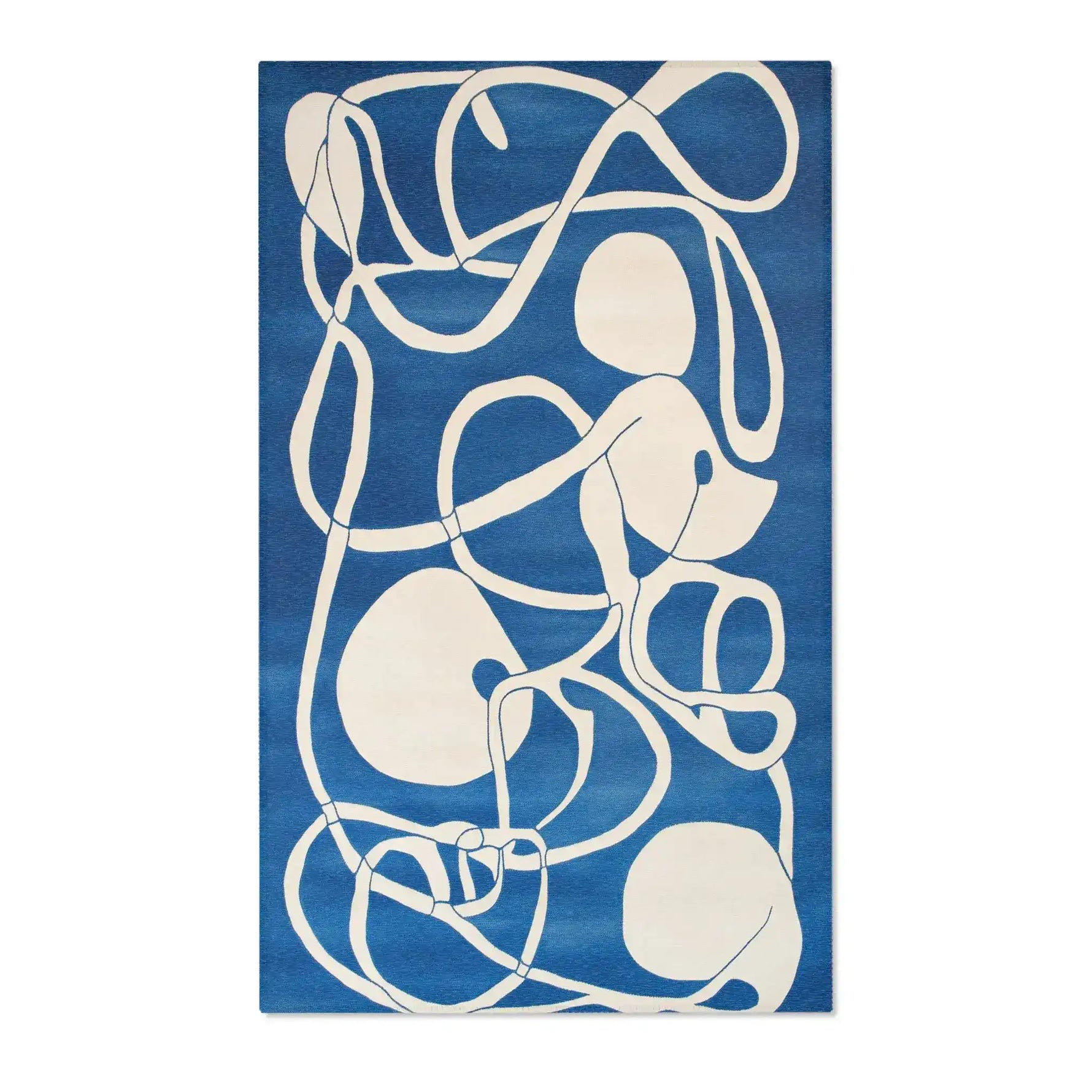 Ocean Flow rug shown face-down revealing plain white surface with small glimpse of crocodile portrait at edge