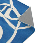 Ocean Flow Abstract Blue and White Rug corner fold with bold white geometric line pattern on cobalt blue, grey backing angled
