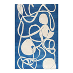 Ocean Flow rug rolled corner close-up showing dark animal portrait print with red rooster feathers and grey backing tube