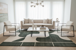 Modern living room with a beige and green rug, sofa, coffee table, and chairs on a patterned rug.