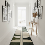 Long rectangular rug with geometric pattern on a white floor, hallway setting.