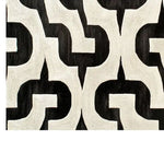 A contemporary wool area rug with a bold black and white geometric pattern, perfect for enhancing modern living room spaces. This hand-tufted rug adds a touch of sophistication to any living room area.