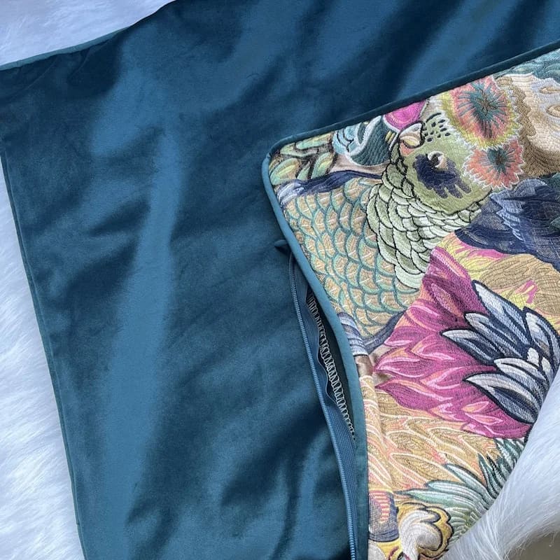 Opulent jungle aviary throw pillow cover featuring vibrant tropical patterns and a luxurious teal backing.