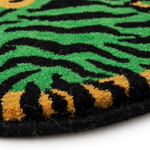 Close-up of a green, black, and gold patterned rug.