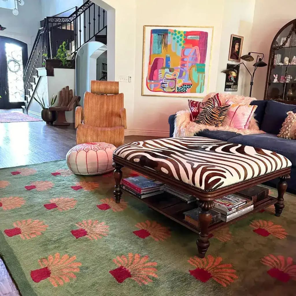 Stylish living room featuring a large area rug with an abstract orange palm tree design on a green tufted wool surface. Ideal for office spaces, this wool rug adds warmth and personality to the room, complemented by eclectic furniture and vibrant artwork.