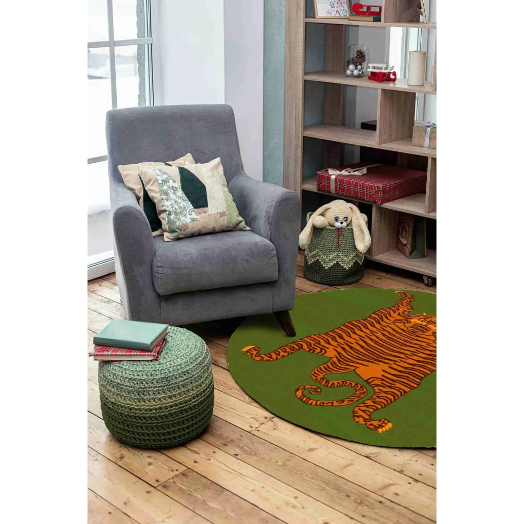 Stylish living room featuring an Orange Tibetan Tiger Green Hand Tufted Round Rug. This wool area rug adds a pop of color with its vibrant tiger design, perfect for large area rugs in an office or living room setting. The rug complements the cozy armchair, decorative pillows, and wooden shelves creating a warm and inviting atmosphere.