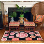 A vibrant Orbit Bloom Hand Tufted Area Rug in a cozy living room setting. The rug features bold, circular patterns in pink and orange hues, perfect for adding a vintage touch to any living room or dining room. Ideal for those seeking a stylish 8x10 wool rug that complements both traditional and modern decor.