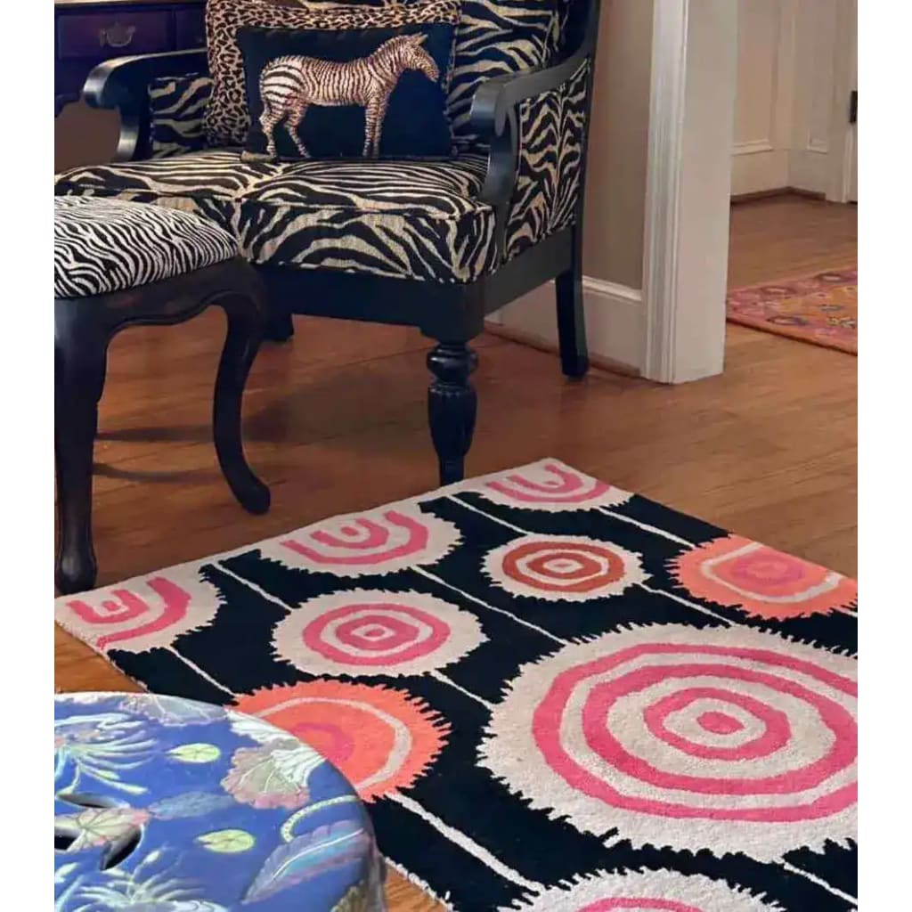 A vibrant Orbit Bloom Hand Tufted Rug in an abstract design featuring concentric circles in pink, orange, and black, perfect for adding a pop of color to a dining room or living room. Ideal for those seeking an 8x10 vintage wool rug to enhance their living space.