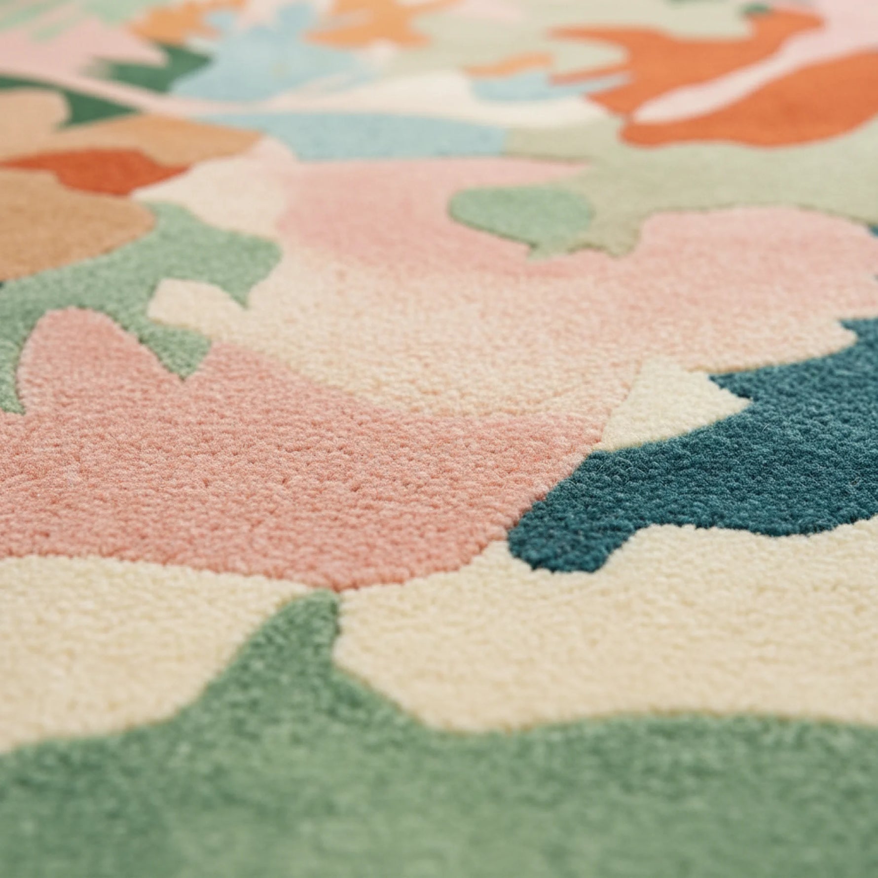 Close-up of a floral-patterned rug with pastel colors.