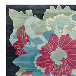 Top view of an Organic Flame Garden Hand Tufted Rug, showcasing a vibrant floral design with bold red, blue, and green hues. This square area rug offers a contemporary touch, perfect for adding a lively flair to your living room. Crafted from high-quality wool, this area rug blends style and comfort seamlessly.