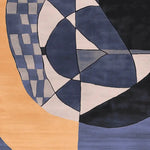 Close-up view of a hand-tufted area rug featuring a contemporary geometric design. The wool rug displays an abstract pattern with shades of blue, black, and beige, perfect for adding a modern touch to large living room spaces.
