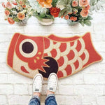 Colorful Oriental Fish Door Mat on a white brick floor, surrounded by vibrant floral arrangements. Perfect as an eye-catching addition to living room area rugs, this area rug showcases a playful fish design ideal for those seeking unique rugs for living room decor.