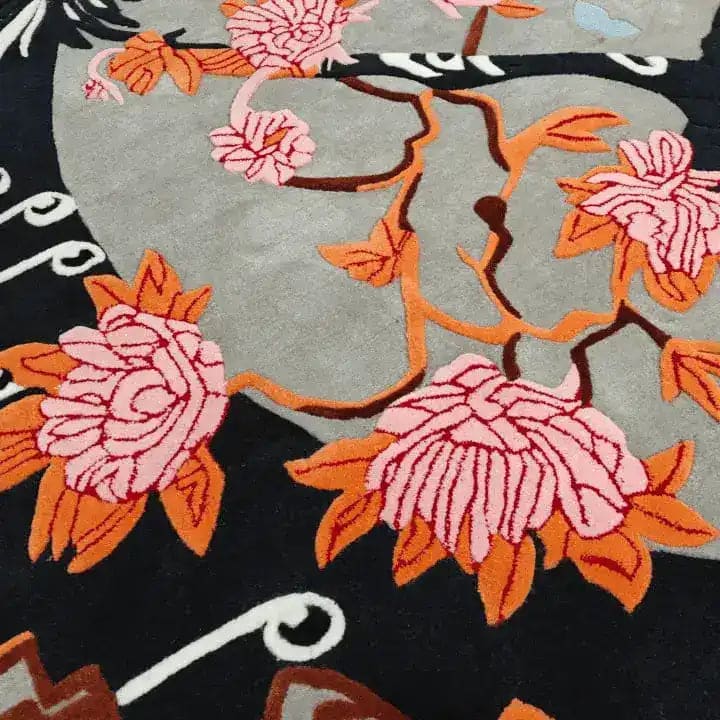 Close-up view of the Oriental Reverie Hand Tufted Rug, showcasing intricate floral patterns in pink and orange hues. This luxurious wool rug adds a touch of elegance to any bedroom or living room, making it an ideal choice for those seeking stylish bedroom area rugs.