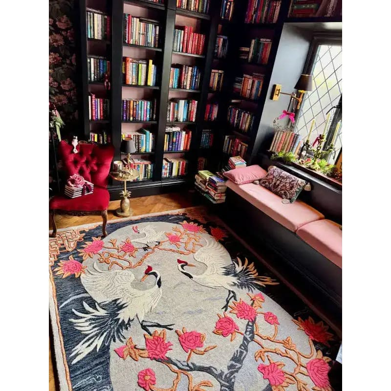 Cozy reading nook featuring a stunning Oriental Reverie hand-tufted area rug with an intricate floral design, perfect for bedroom or living room decor. The elegant wool rug complements the surrounding bookshelves and plush seating, creating a warm and inviting atmosphere.