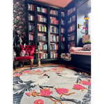 Stylish Oriental Reverie hand-tufted area rug featuring a striking floral pattern with cranes, set in a cozy reading nook with a plush red chair and floor-to-ceiling bookshelves. Perfect for adding elegance to bedrooms or living rooms.