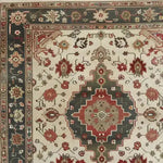 Close-up of an ornamental floral hand-knotted area rug showcasing a vintage Persian design. The intricate pattern features vibrant reds and greens with floral motifs, perfect for adding elegance to living room areas. Ideal for 8x10 spaces, this rug offers a timeless and sophisticated touch.