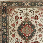 Close-up of an ornamental floral hand-knotted area rug showcasing a vintage Persian design. The intricate pattern features vibrant reds and greens with floral motifs, perfect for adding elegance to living room areas. Ideal for 8x10 spaces, this rug offers a timeless and sophisticated touch.