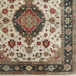 This is a detailed view of an ornamental floral hand-knotted area rug, showcasing intricate Persian-inspired designs with a vintage charm. The rug features a central medallion surrounded by rich floral patterns, making it a perfect addition to any living room setting. Its 8x10 size ensures it covers a substantial floor area, providing both style and comfort to your space.
