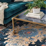 A beautifully ornate blooms hand tufted area rug under a stylish glass coffee table. This wool rug, featuring intricate floral patterns in rich blue and beige tones, adds a vintage charm to a cozy living room setting. Perfect as a dining table rug or for enhancing both living room and dining room spaces with a touch of elegance.