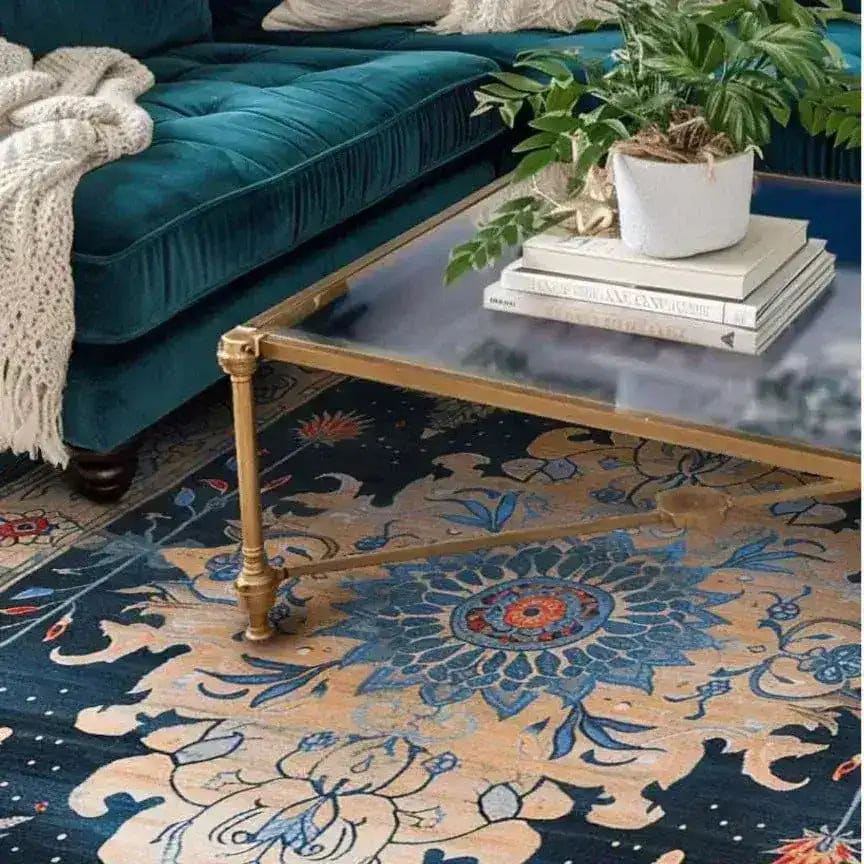 A beautifully ornate blooms hand tufted area rug under a stylish glass coffee table. This wool rug, featuring intricate floral patterns in rich blue and beige tones, adds a vintage charm to a cozy living room setting. Perfect as a dining table rug or for enhancing both living room and dining room spaces with a touch of elegance.