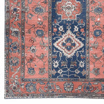 This image showcases a beautifully crafted area rug with intricate designs and vibrant colors. The ornate patterns feature a mix of floral and geometric elements in rich coral and deep blue hues, perfect for adding a vintage touch to any living space. Ideal as a wool rug for living room decor, this 8x10 hand-tufted piece brings elegance and warmth to your home.