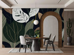 Oversized botanical leaf mural in dining room with arched doorway, round table and gray chairs