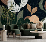 Oversized botanical wallpaper, abstract leaves in navy, green and terracotta behind green sofas and terrazzo table