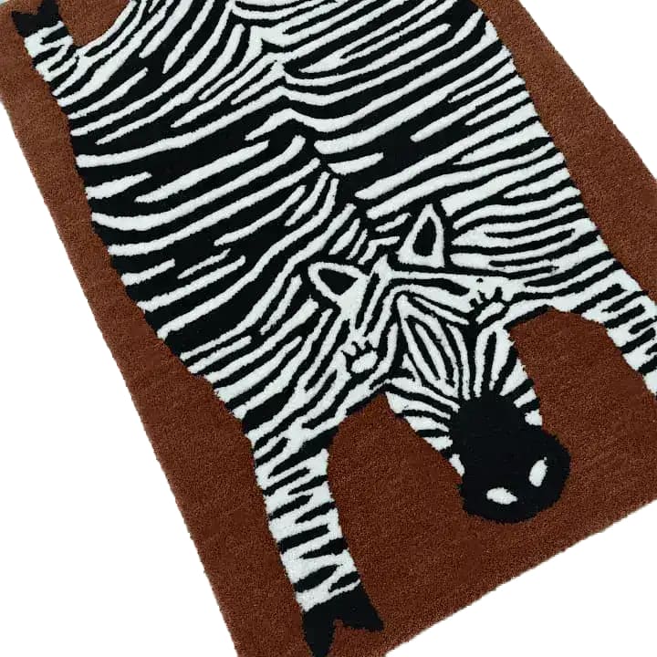 This image features an oversized zebra hand-tufted wool rug, perfect for adding a unique touch to your living room or dining room area. The rug showcases a detailed zebra design in black and white on a warm brown background, making it a striking piece for any space.