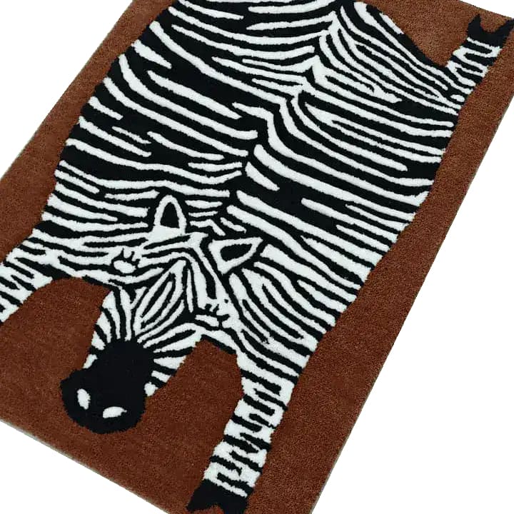 A stylish oversized zebra hand tufted wool rug, perfect for adding a unique touch to your dining room or living room. This area rug features a striking zebra design on a rich brown background, ideal for those seeking distinctive living room area rugs or dining room area rugs.