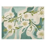 A close-up view of the Painterly Petal Dream Hand Tufted Rug, showcasing its artistic floral design. This contemporary wool rug features soft, flowing patterns in shades of teal, cream, and green, ideal for enhancing living room area rugs collection.