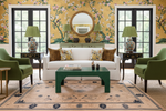Living room with floral wallpaper, green chairs, floral rug, and a white sofa.