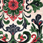 A close-up view of the Palatial Blooms Hand Tufted Rug featuring an elegant and intricate floral pattern in rich red, green, and black hues against a soft cream background. This vintage wool area rug is perfect for adding a touch of sophistication to your dining room or living room, making it an ideal choice for formal dining room settings.