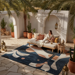 Woman sitting on a couch in a stylish outdoor patio with decorative rug and plants.