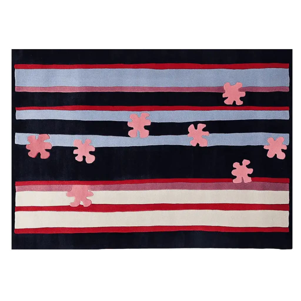 A contemporary wool area rug featuring a bold design with horizontal stripes in shades of red, blue, and white, accented by abstract pink floral shapes. Ideal for adding a modern touch to living room spaces.
