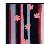 Top view of the Parallel Petals Hand Tufted Area Rug, showcasing a contemporary design with bold vertical stripes in red, blue, and pink hues, accented by abstract floral patterns. This wool rug is perfect for adding a modern touch to your living room decor.