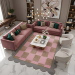 Pink checkered scalloped rug in a glam living room with mauve sofas and marble coffee table
