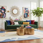 Modern living room with a green sofa, colorful pillows, and a gold coffee table.