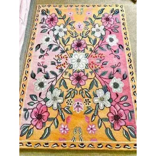 The Pastel Paradise Hand Tufted Rug showcases a vibrant floral design in shades of pink, yellow, and white, perfect for adding a touch of elegance to any living room. This vintage wool rug features intricate floral patterns, making it an ideal choice for those seeking stylish living room area rugs.