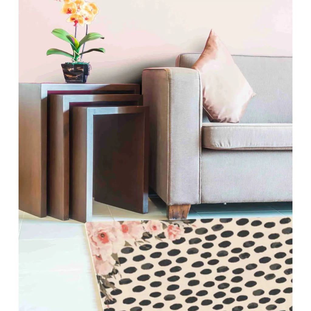 A stylish pastel pink floral animal print area rug adding charm to a cozy living room setting. The hand-tufted wool rug complements the modern sofa and nested tables, ideal for both living room and dining room spaces.