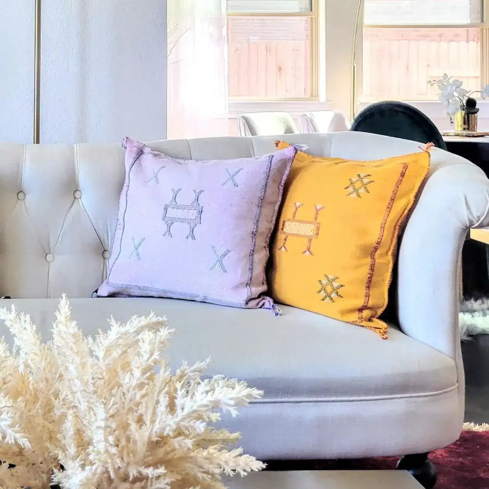 Pastel pink handwoven cactus silk throw pillow cover on a stylish couch, adding a touch of elegance to home decor.