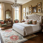 Luxurious bedroom with a large bed, decorative pillows, a traditional wool rug, and framed artwork on the wall.
