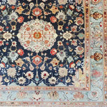 A beautifully intricate floral pattern adorns this hand-knotted wool area rug, showcasing rich, vintage-inspired designs. The square area rug features vibrant colors on a deep blue background, perfect for adding elegance to living rooms or offices. This Persian-style rug offers a touch of timeless charm and is ideal for those seeking luxurious rugs for living rooms.