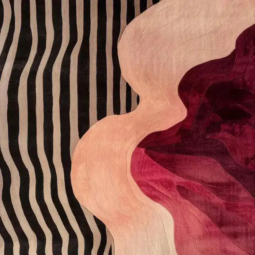 This contemporary wool area rug features a striking abstract design with flowing pink and red shapes against a backdrop of bold black and beige stripes. Perfect for adding a touch of modern elegance to any bedroom, this hand-tufted rug embodies the essence of stylish bedroom area rugs.