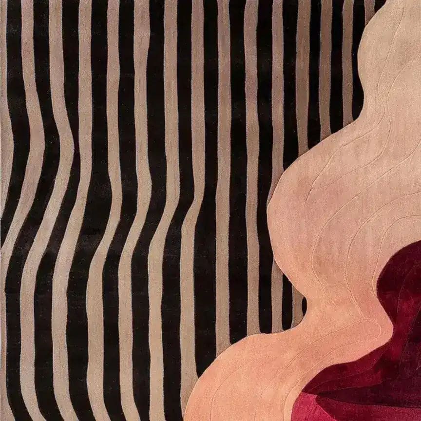 Contemporary area rug featuring a striking abstract design with wavy black and beige stripes on one side, blending into a swirling pattern of pink and red hues. Ideal for adding a modern touch to bedroom decor, this hand-tufted wool rug offers both style and comfort, making it a perfect choice for bedroom area rugs.